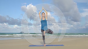 The girl is making yoga pose on beach in Vietnam. Exercises calmness and harmony