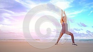 The girl is making yoga pose on beach in Vietnam. Sea or ocean happy woman relaxation. Water and waves. Hands and blue