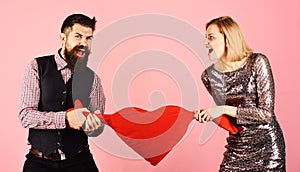 Girl and man with angry faces play with toy heart