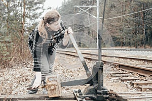 The girl manually passes the arrows on the railroad tracks. daylight. there is toning