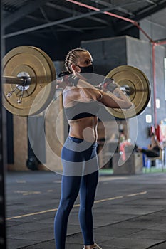 Girl with mask in a gym doing Cross training