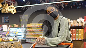 Girl in a mask has shopping in the supermarket