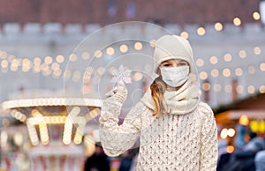 girl in mask with snowflake over christmas market