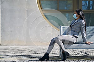 Girl with a mask to avoid contagion walking down the street. Coronavirus concept