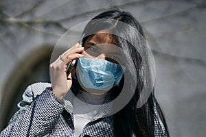 Girl with a mask to avoid contagion walking down the street. Coronavirus concept