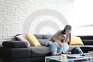 Girl Massaging Boyfriend On Sofa At Home