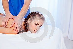 Girl masseur doing massage back spa health