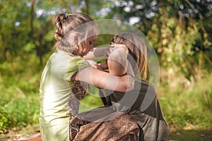 Girl masseuse thuroughly massages a girl in the daylight. photo