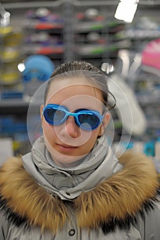 Girl measures the goggles in the store