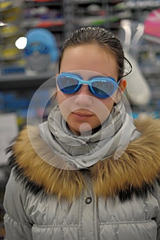 Girl measures the goggles in the store