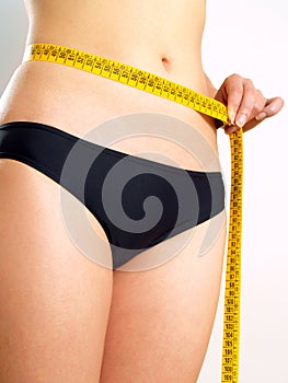 Girl measuring her abdomen after diet photo