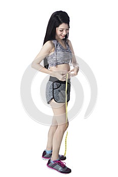 Girl measuring her slim waistline