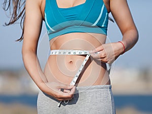 Girl measuring her waist