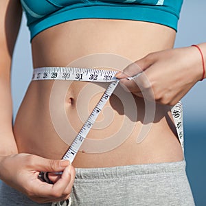 Girl measuring her waist