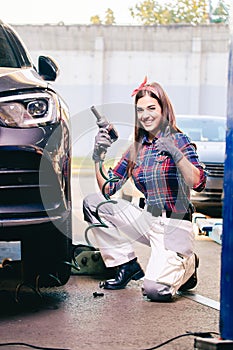 Girl mechanic changing tires