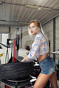 Girl mechanic replace tires on wheels