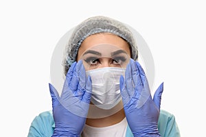 A girl in a medical mask, gloves and a robe with a syringe in his hands on a white background. Beautician, beauty specialist.