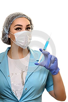 A girl in a medical mask, gloves and a robe with a syringe in his hands on a white background. Beautician, beauty specialist.