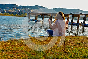 Girl meditating by the lake during the golden hour