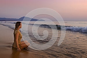 A girl meditating on the ocean shore