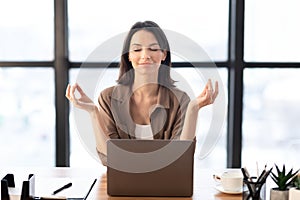 Girl meditating in office coping with stress at work