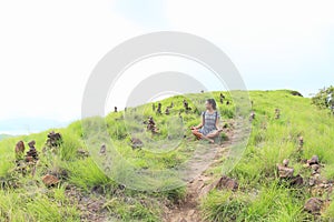 Girl meditating among stone stacks on Padar Island photo