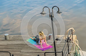 The girl is meditating on the terrace by the river