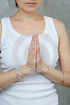 Woman in white shirt doing meditation yoga mudra of hands and relax. close-up