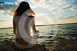 Girl meditations near water