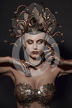 Girl Medusa headdress of gold color on a black background