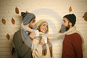 Girl and men at brick wall drink hot wine.