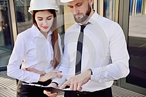 A girl with a man in construction white helmets and white shirts