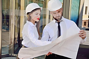 A girl with a man in construction white helmets and white shirts