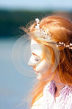 Girl with a mermaid tail on the river bank. Mystical and fairytale heroine. A sensation on vacation