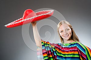 The girl in mexican vivid poncho against gray
