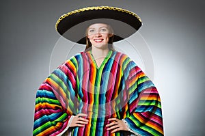 The girl in mexican vivid poncho against gray