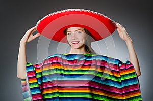 The girl in mexican vivid poncho against gray