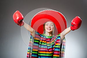 The girl in mexican vivid poncho and box gloves