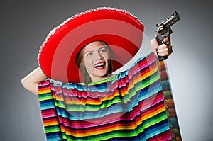 The girl in mexican vivid poncho holding handgun
