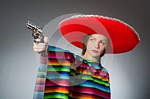 The girl in mexican vivid poncho holding handgun