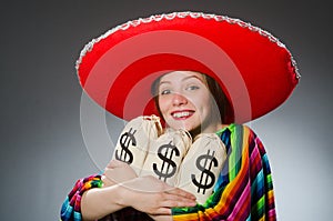 Girl in mexican vivid poncho holding money bags