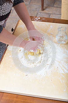 Girl is mixing by hand the water, flour and an egg