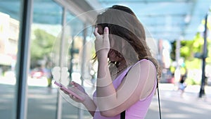 Girl with a mobile phone Canada Vancouver Wind blows smiling young woman In city center, young girl in pink dress walks