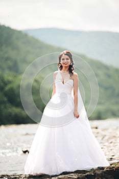 Girl, model, bride on a background of the river and mountains. Beauty portrait