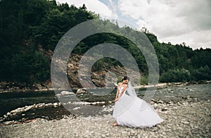 Girl, model, bride on a background of the river and mountains. Beauty portrait