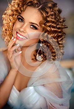 Girl model with dense, curly hair, dressed in evening gown.