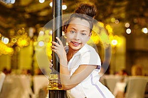 Girl-model stands, leaning decorative lamppost