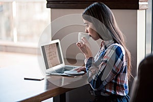 Girl working with laptop in cafe