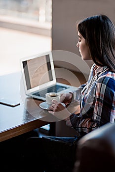 Girl working with laptop in cafe