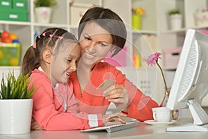 Girl with mother doing shopping online